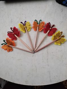 a bunch of colorful felt flowers sitting on top of a white table