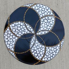 a black plate with white and gold designs on it