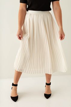 Add an elevated skirt to your wardrobe with the 'Theodora' Pleated Midi Skirt in a soft, timeless cream color! This skirt features a pleated design that offers free movement with every step, and offers a flattering and sophisticated silhouette. The midi length is graceful and versatile, making it easy to dress up, or dress down. The 'Theodora' skirt will soon become your new go-to for refined, effortless style! 100% Polyester Fully Lined Machine Wash Cold, Gentle Cycle Non-Chlorine Bleach Only T Free Movement, Layered Tops, Pleated Midi Skirt, Skirt Leggings, Blouse Dress, Tops For Leggings, Dressed Down, Exclusive Designs, Cream Color