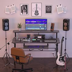 a desk with guitar, keyboard and other musical equipment in front of pictures on the wall