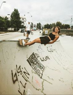 a woman riding a skateboard up the side of a ramp at a skate park