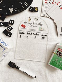 some cards, dices and pens are laying on a white sheet with the names of each card