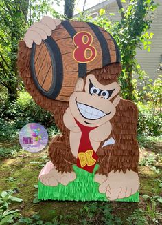 a cardboard cutout of a gorilla holding a wooden barrel with the number eight on it