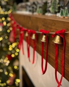 the bells are hanging on the mantle by the christmas tree