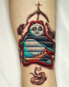 a tattoo on the leg of a person with a panda bear and snake in it