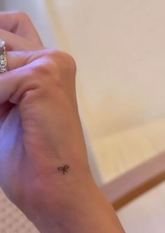 a woman's hand with a small tattoo on her left wrist and the word love written in it