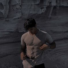 a man standing in front of a rock formation looking at his cell phone