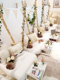 a room filled with white couches covered in lots of pillows and flowers on them