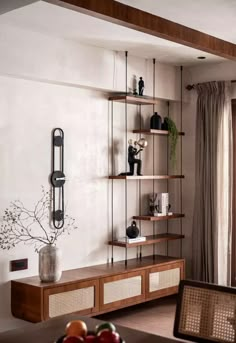 a living room filled with lots of furniture next to a wall mounted book shelf covered in books