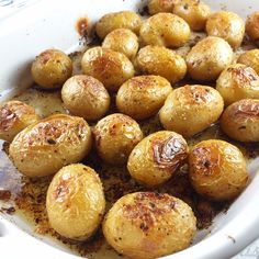 cooked potatoes in a white dish with seasoning sprinkled on the top and bottom