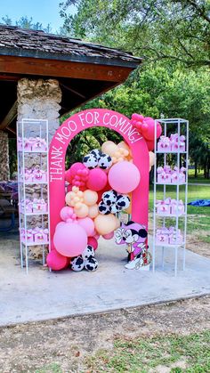 a pink and white balloon arch with minnie mouse balloons on it in front of a gazebo