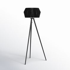 a tripod floor lamp with a black shade on it's top and legs