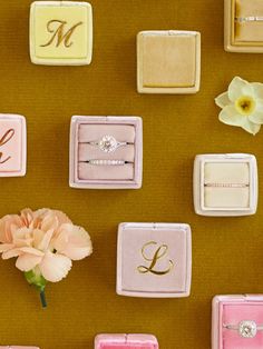 wedding rings, ring boxes and flower displayed on brown background with monogrammed initials