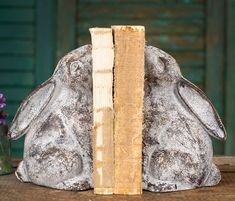 a book that is sitting on top of a table with a rabbit statue next to it