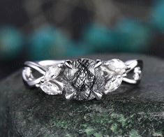 three stone diamond ring sitting on top of a rock