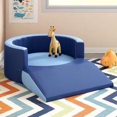 a giraffe sitting on top of a blue chair in a child's room