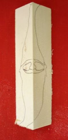 a piece of paper that has been drawn on the side of a red wall with an image of a woman's face