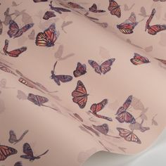 a pink background with many butterflies on it