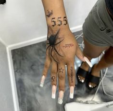 a woman's hand with tattoos and numbers on it