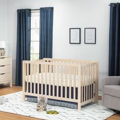 a baby crib in a room with blue curtains