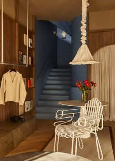 a white chair sitting next to a table on top of a hard wood floored floor