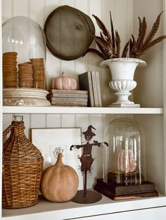 two shelves filled with vases, books and other decorative items on top of each shelf