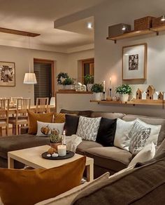 a living room filled with lots of furniture next to a dining room table and chairs