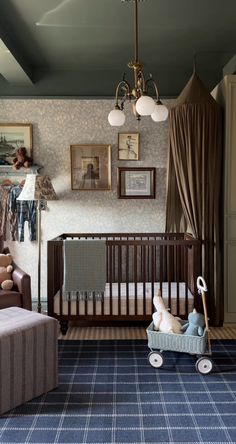 a baby's room with a crib, couch and chair