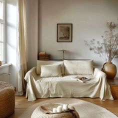 a living room filled with furniture and a white couch covered in a blanket next to a window