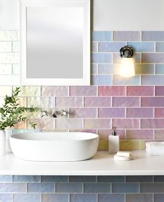 a white sink sitting under a bathroom mirror next to a wall mounted faucet