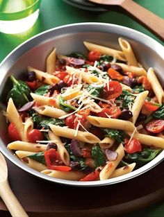 a bowl filled with pasta and vegetables on top of a table