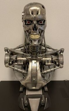 a silver robot with red eyes on a black table