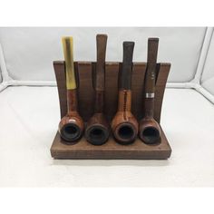 a set of five wooden pipe holders with different types of pipes in them on a white background