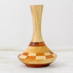 a wooden vase sitting on top of a white counter next to a wall and floor