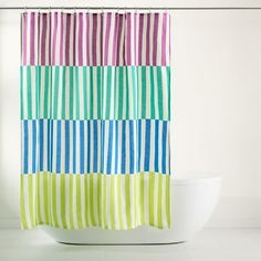 a colorful shower curtain hanging on the side of a bath tub