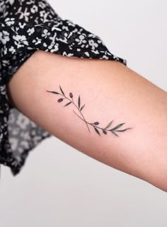 a woman's arm with a small tattoo on it