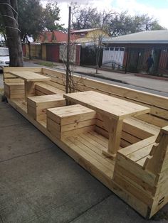 wooden benches are lined up on the sidewalk