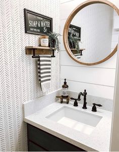 a bathroom sink under a round mirror in front of a wall mounted faucet