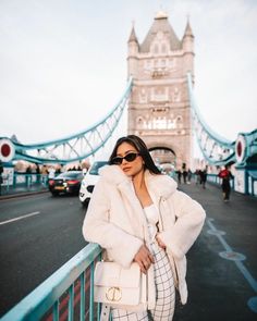 a woman standing in front of a bridge