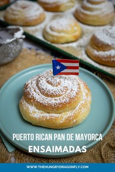 a plate topped with powdered sugar covered doughnuts next to other pastries