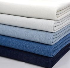 four different colors of fabric stacked on top of each other, one in blue and the other in white