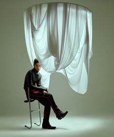 a man sitting in a chair with his legs crossed