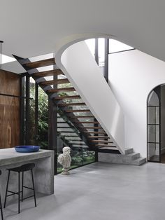 the interior of a modern house with stairs leading up to the second floor and an indoor dining area