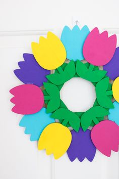 a wreath made out of paper flowers on a door