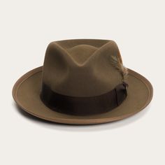 An icon of the Stetson brand, the Whippet Fedora epitomizes the sophisticated style of the American post-war era with its timeless, versatile profile and a brim that can look casual and cool when snapped up, or snapped down for a dressed-up and dapper look. Handcrafted with a firm finish from our proprietary Royal Deluxe quality fur felt and richly dyed in versatile shades, the Whippet features a slightly tapered 4 ½" pinch front teardrop crown and a 2 ⅜” bound edge brim. Its classic style is underscored by a grosgrain hatband, Stetson hat pin and removable feather detail. A premium roan leather sweatband and full satin liner ensure a secure, comfortable, all-day fit. Once an absolute necessity for the respectable mid-century man, Stetson fedoras have been seen on titans of industry, legen Classic Brown Felt Hat With Flat Crown, Classic Brown Flat Brim Felt Hat, Curved Brim Fur Felt Top Hat For Fall, Classic Brown Fedora With Flat Crown, Brown Fur Felt Hat With Flat Crown, Classic Brown Hat With Flat Crown, Brown Short Brim Fur Felt Hat, Flat Brim Fur Felt Hat, Fur Felt Top Hat With Curved Brim For Fall