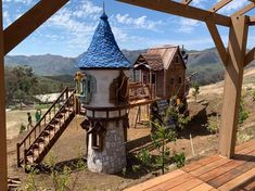 a small house with a blue roof sitting on top of a wooden platform