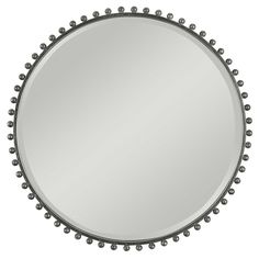 a round mirror with beading around the edges