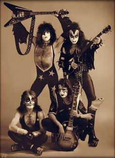 the kiss band is posing with their guitars