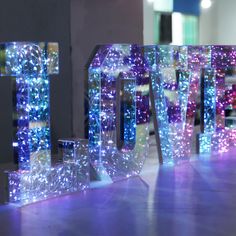 the letters are made out of glass and have lights on them in different colors, shapes and sizes