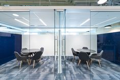 an office meeting room with glass walls and chairs